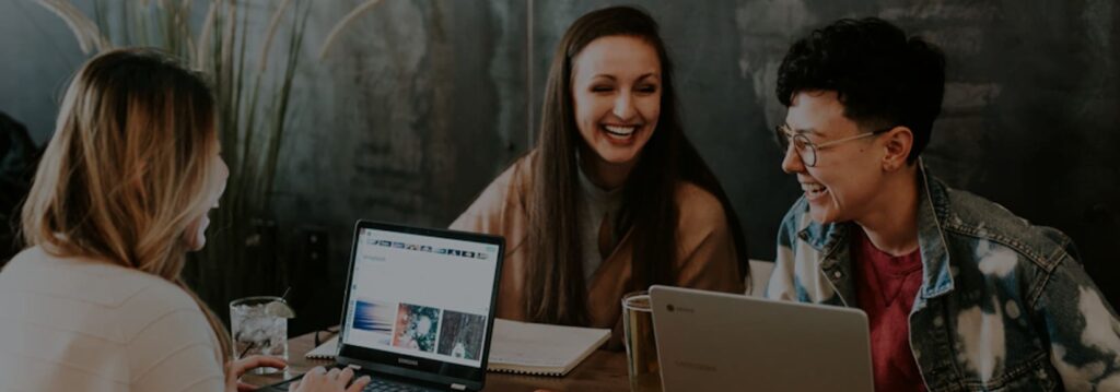 group of people laughing over laptop