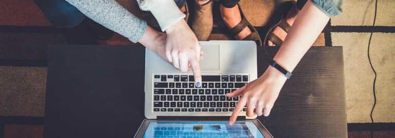 hands pointing at macbook screen