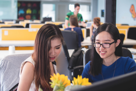 two businesswomen behind a desk