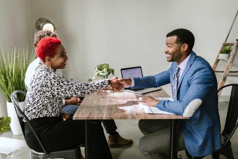 man-shaking-hand-with-woman-across-table-pexels