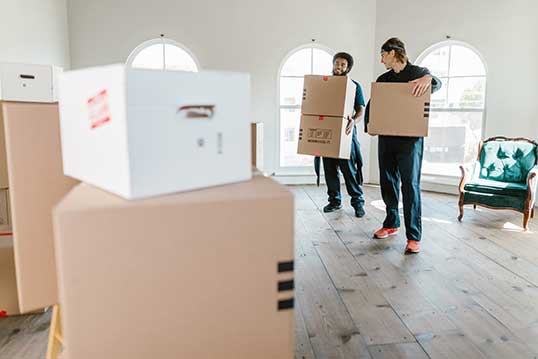 men holding boxes in empty room