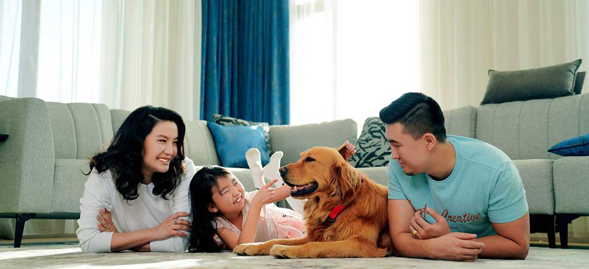 family with pet laying on the floor smiling