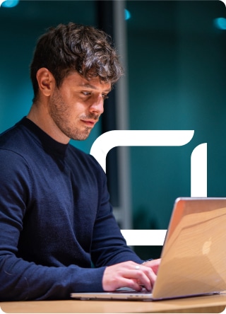 man sitting at desk typing on mac