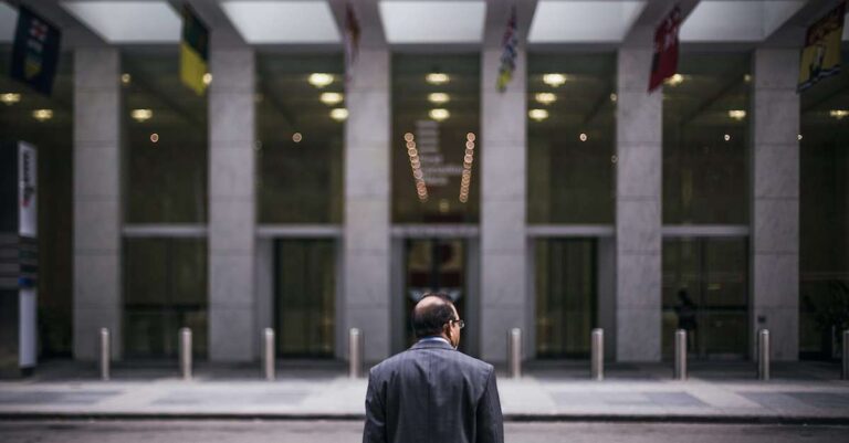 Man in front of large building